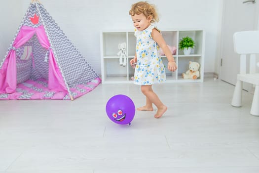 The child is playing with a balloon. Selective focus. Kid.