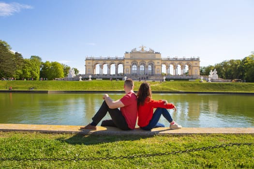 Beautiful sunny day, Sch nbrunn Palace, residence in Vienna, Austria. A girl and a guy are sitting near the fountain