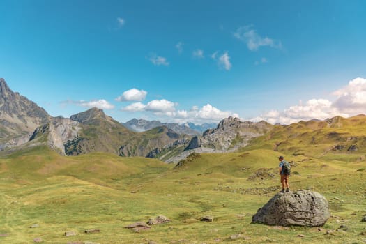 Man hiking in top of a rock in a beautiful valley between mountains during the sunset. Discovery Travel Destination Concept. High quality photo