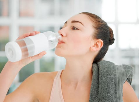 Life is simple, just take it with a sip of water. a young woman drinking water while working out