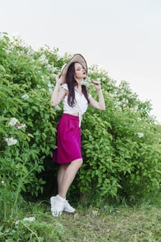 A fashionable girl with dark hair, a spring portrait in lilac tones in summer. Bright professional makeup