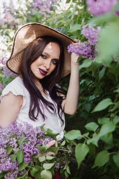A fashionable girl with dark hair, a spring portrait in lilac tones in summer. Bright professional makeup