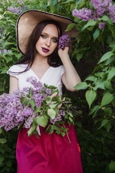 A fashionable girl with dark hair, a spring portrait in lilac tones in summer. Bright professional makeup