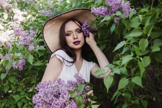 A fashionable girl with dark hair, a spring portrait in lilac tones in summer. Bright professional makeup