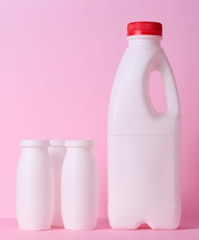 White plastic bottle for milk and dairy products on a pink background