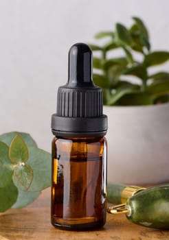 Brown glass bottle with pipette for cosmetic procedures on a wooden background