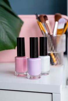 closeup of elegant cosmetic products standing on feminine dressing table, mockup design of nail polish bottle