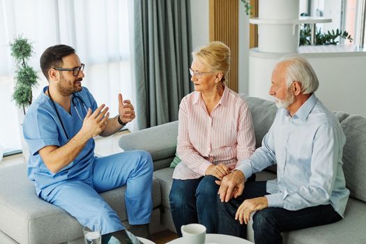 Doctor or nurse caregiver with senior couple at home or nursing home