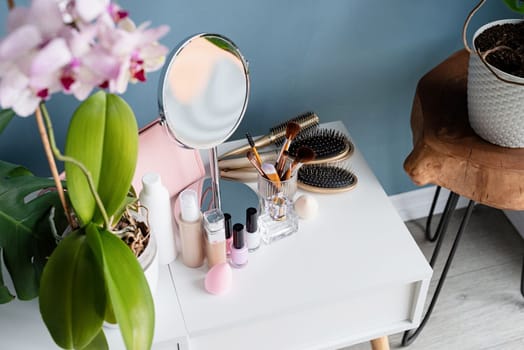 Stylish light room interior with elegant vanity table and plants, beauty and fashion