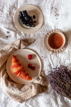 traditional french breakfast of a croissant, grapes and hot chocolate, overhead photo