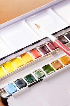 Watercolor tin with pans of colorful paint and brush