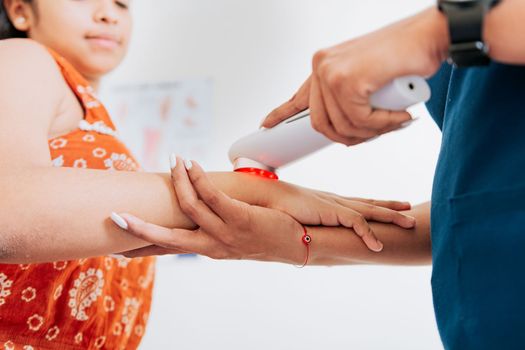 Laser therapy used on the arm to treat pain, Close up of physiotherapist using laser therapy on patient arm. Modern laser physiotherapy on woman patient