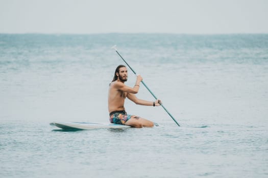 Sea woman and man on sup. Silhouette of happy young woman and man, surfing on SUP board, confident paddling through water surface. Idyllic sunset. Active lifestyle at sea or river