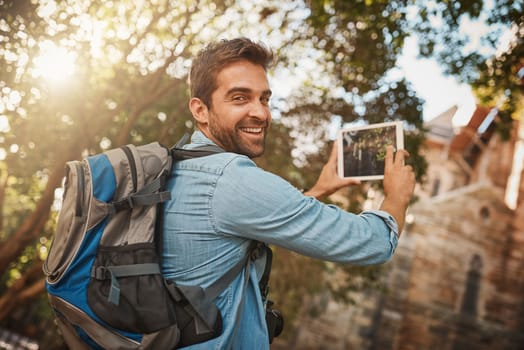 Traveling keeps your feet grounded and your mind humble. a handsome young man taking photographs on his tablet while on vacation