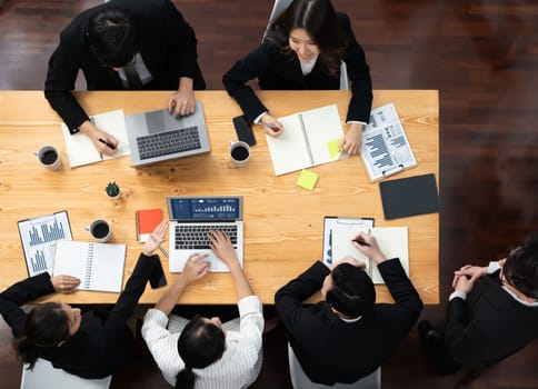 Top view manager or office worker give presentation in harmony conference room to business colleague, BI data dashboard on screen and pile of financial analyzed data reports on meeting table.