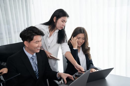 Harmony in office concept as business people analyzing dashboard paper together in workplace. Young colleagues give ideas at manager desk for discussion or strategy planning about project.