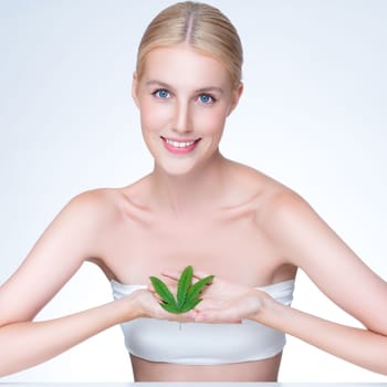 Personable beautiful woman with soft make up and flawless smooth clean skin holding green leaf. Cannabis skincare cosmetic product for natural skin treatment concept in isolated background