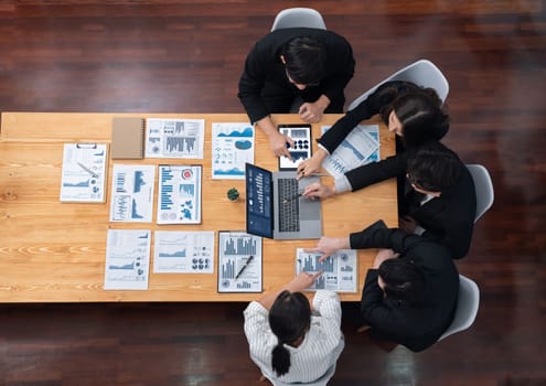 Top-view business team of financial data analysis meeting with business intelligence, report paper and dashboard on laptop for marketing strategy. Business people working together in office of harmony
