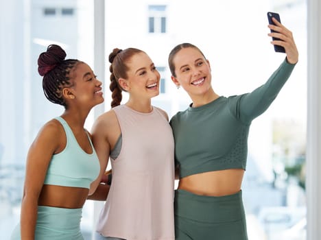 Yoga with my girls. a diverse group of women standing together after yoga and using a cellphone to take selfies