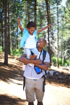 This is so much fun. A happy young african father playing with his daughter while outdoors in nature