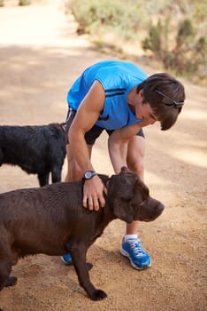Dogs need their exercise too. a young man exercising outdoors with his dogs