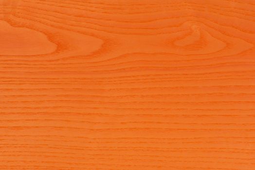 Orange wood texture. The large textured wood of the ash tree is painted orange. Orange ash