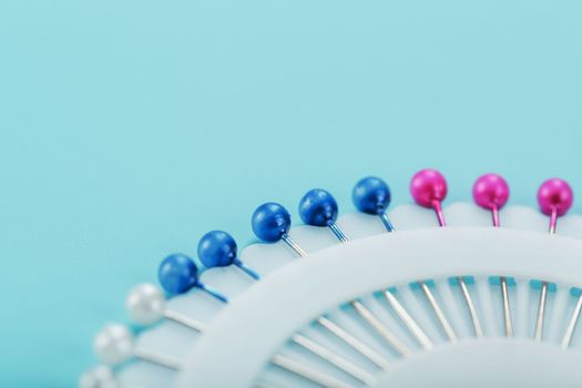 Sewing mother-of-pearl pins in a round white package on a blue background with free space