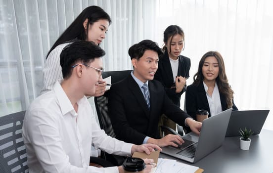 Harmony in office concept as business people analyzing dashboard paper together in workplace. Young colleagues give ideas at manager desk for discussion or strategy planning about project.
