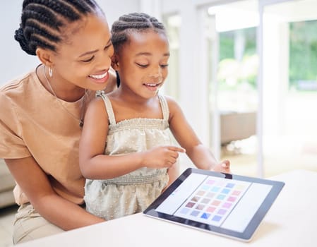 I did it Mommy. an attractive young mother sitting with her daughter and helping her with her motor skills on a digital tablet