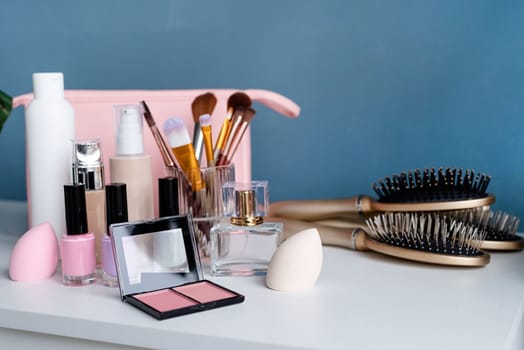 closeup of feminine cosmetic products standing on vanity table, nail polish and face powder