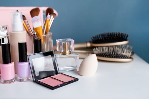 closeup of feminine cosmetic products standing on vanity table, nail polish and face powder