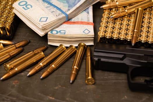 Small arms along with live ammunition for small arms and machine guns. Files of banknotes lying on a wooden box. Trading in weapons and ammunition.