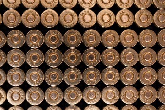 Multiple cartridges stacked one next to the other as seen from the primer side. Sharp small arms ammunition. Top view.
