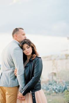 Bride put her head on the groom shoulder holding his hand. High quality photo