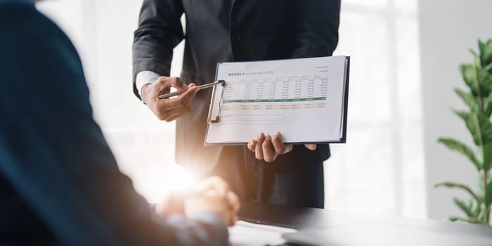 Business People Meeting using laptop computer,calculator,notebook,stock market chart paper for analysis Plans to improve quality next month. Conference Discussion Corporate Concept....