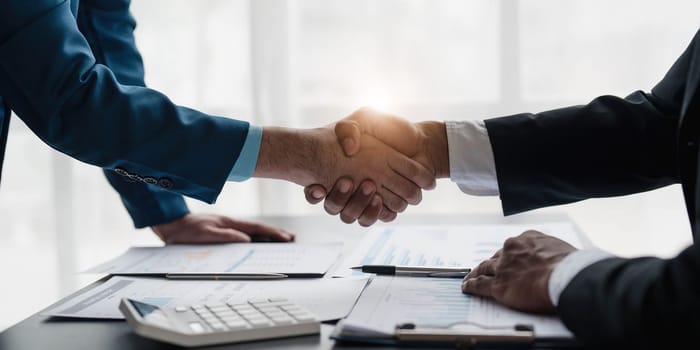 Business handshake for teamwork of business merger and acquisition,successful negotiate,hand shake,two businessman shake hand with partner to celebration partnership and business deal concept...