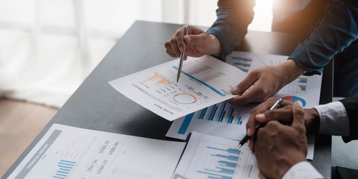 Business People Meeting using laptop computer,calculator,notebook,stock market chart paper for analysis Plans to improve quality next month. Conference Discussion Corporate Concept....