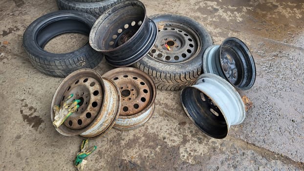 Car wheels rims and tires lie on the floor in the workshop.