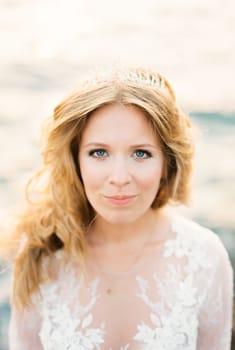 Bride in a white lace dress with a tiara on her hair. High quality photo