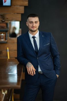 portrait of a bearded groom guy in a dark blue suit