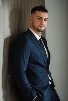 portrait of a bearded groom guy in a dark blue suit