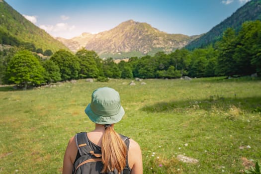 Young Woman With A Backpack hiking in a beautiful valley between mountains during the sunset. Discovery Travel Destination Concept. High quality photo