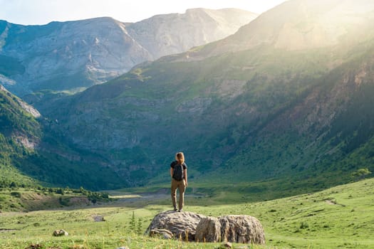 Young Woman With A Backpack on The Top Of a rock in a Beautiful wild Landscape. Discovery Travel Destination Concept. High quality photo