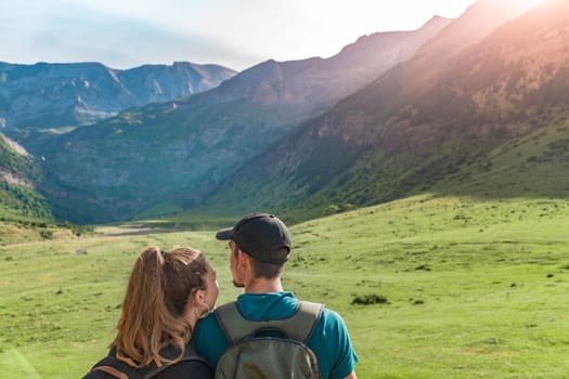 Young Couple in a beautiful valley between mountains during the sunset. Discovery Travel Destination and Freedom Concept. High quality photo.