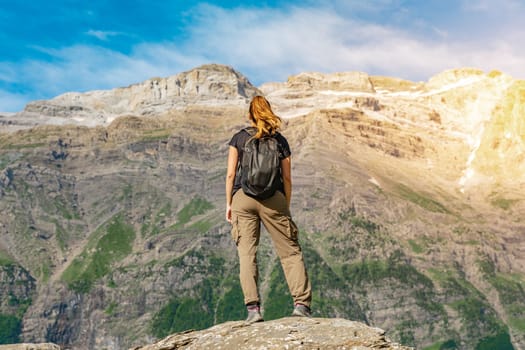 Young Woman With A Backpack on The Top Of a rock in a Beautiful wild Landscape. Discovery Travel Destination Concept. High quality photo