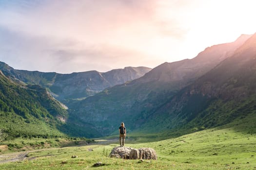 Young Woman With A Backpack on The Top Of a rock in a Beautiful wild Landscape. Discovery Travel Destination Concept. High quality photo