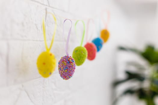 Easter eggs hanging on the clothesline isolated on white