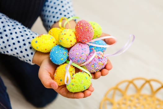 Cute smiling little girl with basket full of colorful easter eggs