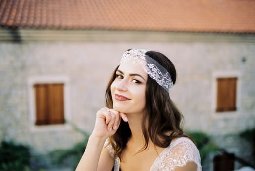 Bride sits, resting her chin on her hand. High quality photo