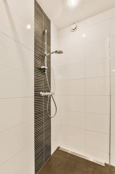 a modern bathroom with black and white tiles on the walls, shower headrests, and hand held against the wall